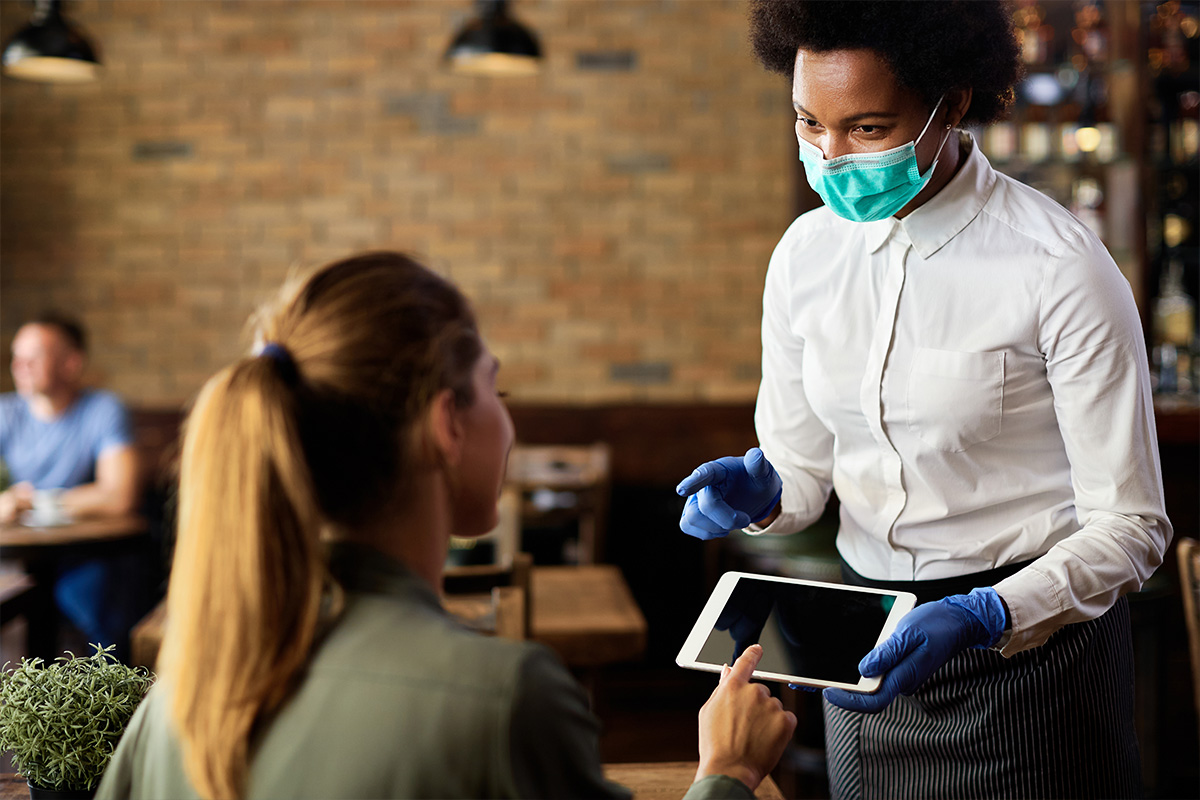 Serveuse présentant une tablette à un client dans un restaurant